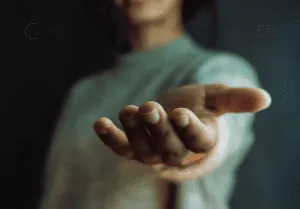 Persona extendiendo la mano abierta hacia adelante, en señal de ayuda