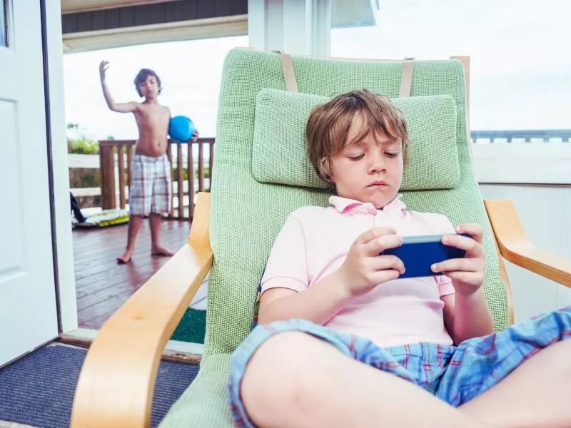 Niño sentado en un sillón mirando una pantalla
